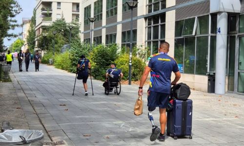 Des athlètes handisport qui entrent au village olympique.