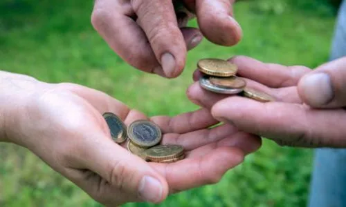 Zoom sur les mains de deux personnes qui s’échangent des euros.