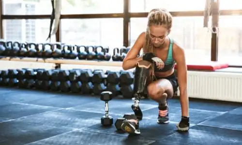 Femme amputée munie d’une prothèse de jambe dans une salle de gym.