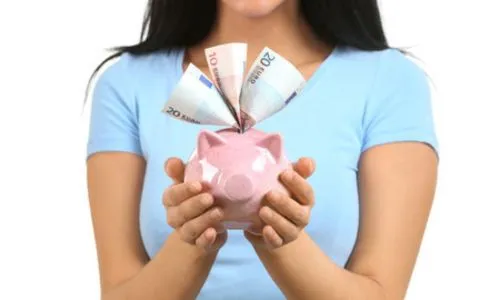 Une femme tient entre ses mains une tirelire d’où sortent des billets.