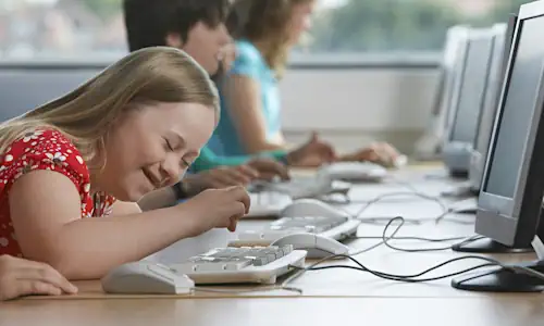 Jeune fille tapant sur un clavier d'ordinateur