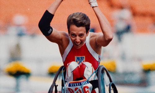Une athlète en fauteuil lève les bras au ciel au Jeux de Séoul 1988