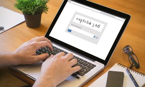 Un homme, sur son ordinateur, remplit un Captcha.