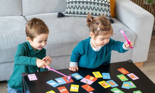 Deux enfants tiennent des ventouses devant un jeu de cartes