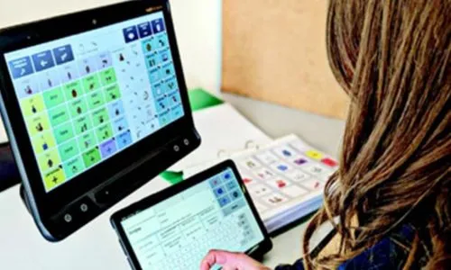 Une femme devant son ordinateur utilise la Communication alternative améliorée.