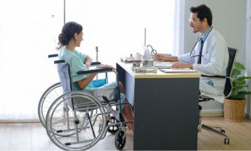Un médecin face à une patiente en fauteuil roulant.