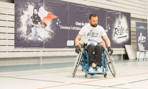 Le para athlète Michael Jeremiasz devant une affiche du programme La Relève.