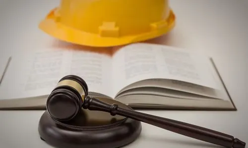 Au 1er plan, un maillet, puis le Code civil ouvert et un casque de chantier.