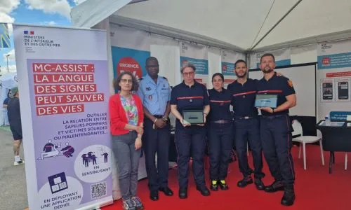 Des pompiers montrent l’appli MC-ASSIST sur une tablette.