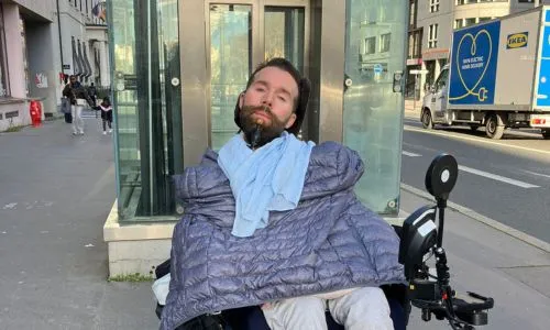 Antoine Durand, en fauteuil roulant, devant un ascenseur pour accéder au métro.