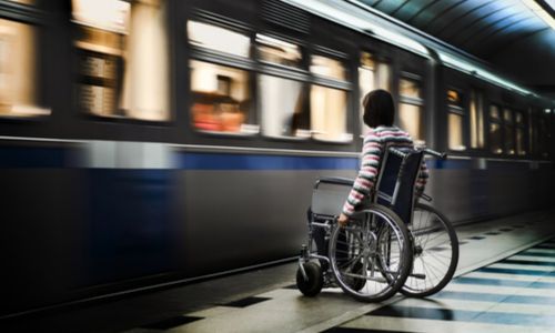 Une femme en fauteuil roulant attend le métro.