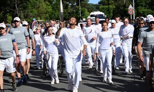 Porteurs de la flamme olympique habillés en blanc.