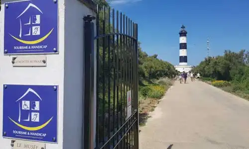 Au 1er plan, le logo du label Tourisme et handicaps et, au loin, un phare.