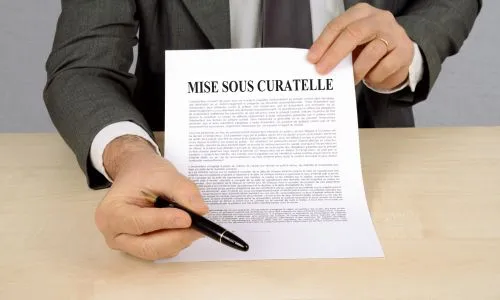 Un homme tient une feuille sur laquelle est inscrite « mise sous curatelle ».